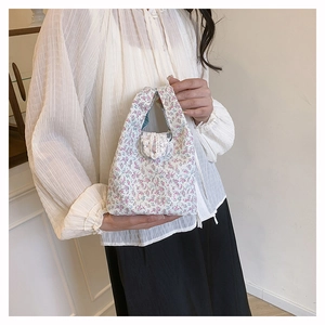 Détail du sac cabas floral avec bordure en dentelle et motifs de fleurs pastels