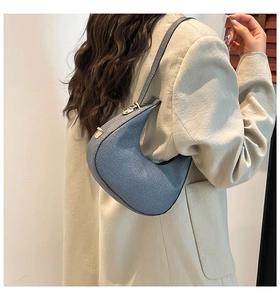 Seitenansicht der hellblauen Halbmod-Tasche kombiniert mit einem beigen Leinenblazer