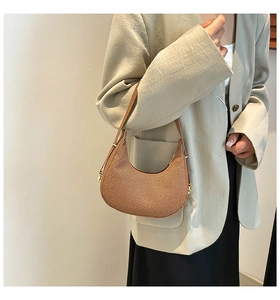 Nahaufnahme der braunen gewebten Hobo-Tasche mit goldenen Details an der Schulter