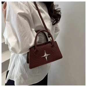 Close-up of wine red woven crossbody bag featuring a silver star metal buckle