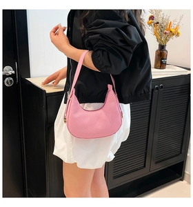 Schicke rosa Halbmond-Untertasche mit Steinstruktur, getragen von einem Modell in Innenräumen