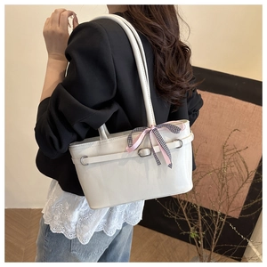 Detail of white PU leather baguette bag with checkered bow and metal buckle accent