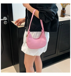 Detailansicht der rosa Halbmond-Tasche mit Steinstruktur und goldenen Beschlägen