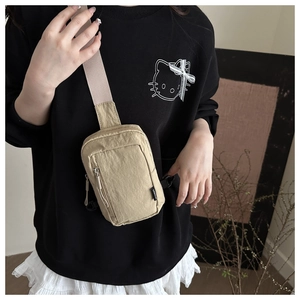 Close-up of lightweight nylon mini crossbody bag worn by model in beige khaki tone
