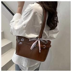 Borsa tote in ecopelle marrone con fiocco a quadri rosa indossata sulla spalla di un modello