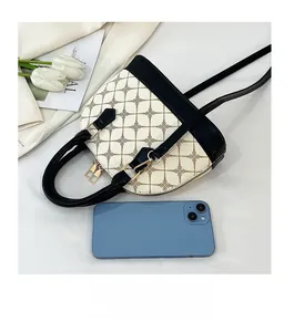 Detail view of vintage shell handbag compared to a smartphone for clear size reference