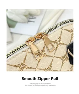 Detail of smooth gold double zippers on beige lychee leather bag with brand pattern