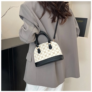 Detail of vintage shell-shaped handbag featuring geometric print and dual-strap versatility