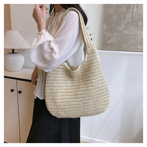 Close-up of the beige woven shoulder bag showing fine handmade crochet texture and large capacity