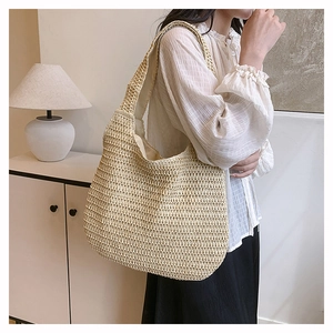 Detailed view of handmade hollow-knit straw shoulder bag with natural woven texture