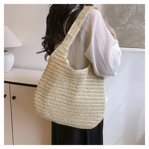 Close-up of beige woven straw tote bag texture with natural hand-knit pattern details