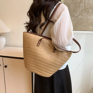 Large woven straw tote bag with brown leather straps for beach holiday outfits