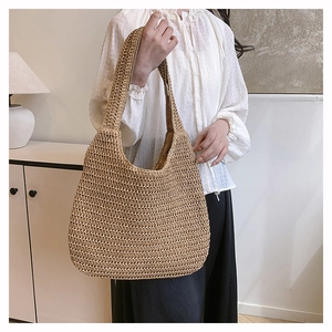 Close-up of hand-woven straw tote bag with dense crochet texture for beach vacation