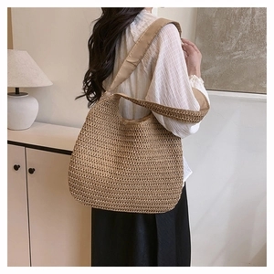 Detail of hand-woven straw shoulder bag with hollow mesh pattern in natural brown tone