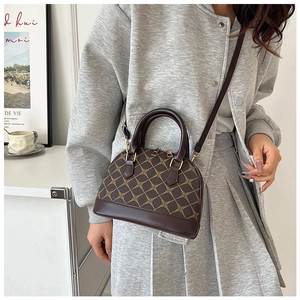Detail of vintage shell-shaped crossbody bag with geometric pattern in a lifestyle setting