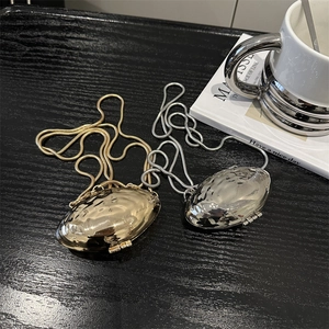 Mini metallic shell-shaped evening bags in gold and silver with textured ripple finish
