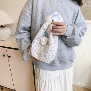 Floral canvas bucket bag for women featuring pastel flower patterns and a cute plush charm