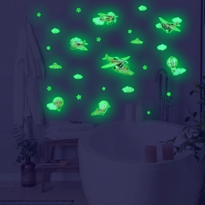Luminous airplane and hot air balloon wall stickers glowing bright green in dark room