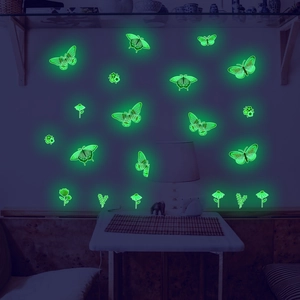 Luminous butterfly and flower wall stickers glowing in bright green light in the dark