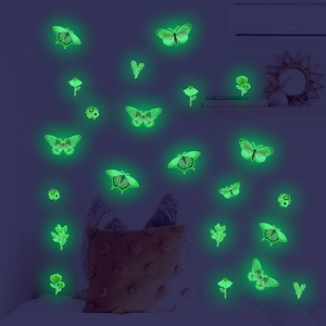 Green luminous butterfly wall decals glowing in dark bedroom with floral patterns