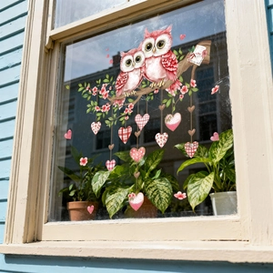 Detailed watercolor window stickers of cute owls and pink hearts on a wooden window