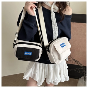 Detail of adjustable strap and blue brand logo on nylon crossbody messenger bag