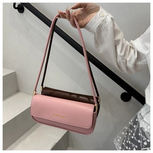Detail of two-tone cylindrical shoulder bag in pink and brown with gold lettering