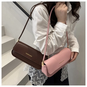 Detail of minimalist rectangular PU leather bags in brown and pink with golden logo