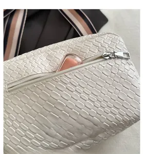 Close-up of white woven leather texture with a silver metal zipper and pink lipstick
