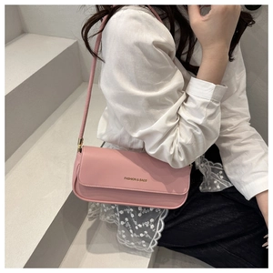 Close-up of pink rectangular shoulder bag in smooth leather with gold lettering