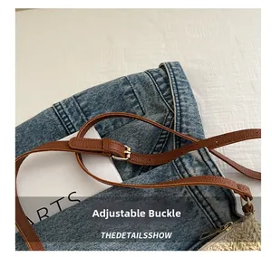 Detail of adjustable brown leather shoulder strap with gold metal buckle on woven bag