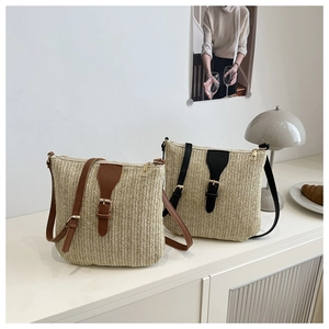 Detail of hand-woven straw crossbody bags with brown and black leather accents