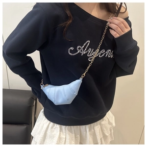 Détail du sac croissant bleu clair avec cuir plissé et bandoulière chaîne dorée