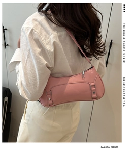 Borsa baguette in finta pelle rosa lucida con fibbie decorative portata a spalla