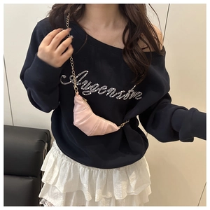 Détail d'un mini sac croissant rose avec une fine bandoulière chaîne dorée pour femme