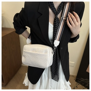 White faux crocodile skin crossbody bag with adjustable striped woven shoulder strap