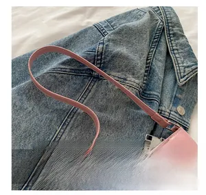 Detail shot of pink faux leather crescent bag featuring a silver zipper and slim handle