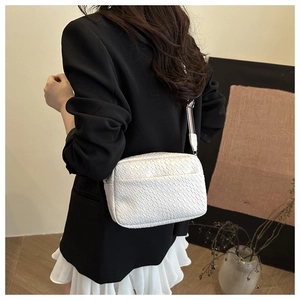 White woven texture crossbody bag styled with a minimalist outfit for a chic appearance