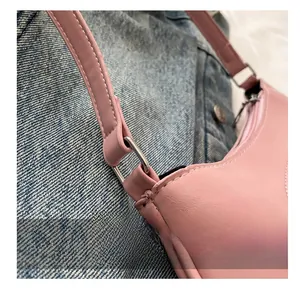 Detail of pink PU leather shoulder bag featuring silver metal rings and stitching texture