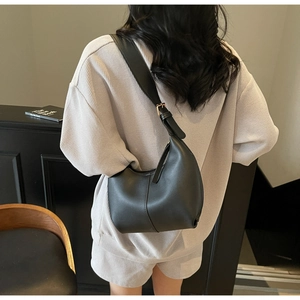 Detail of minimalist black PU leather crescent hobo bag with gold adjustable buckle