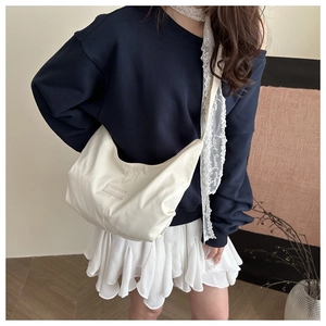 Detailed shot of white crescent canvas shoulder bag with FANYISSA logo and wide strap