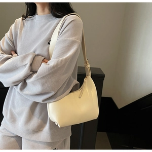 Close-up of cream white PU leather hobo bag showing texture and adjustable strap