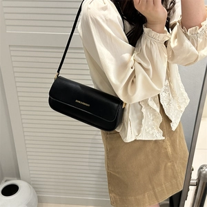 Chic black leather baguette bag with gold lettering and shoulder strap for women