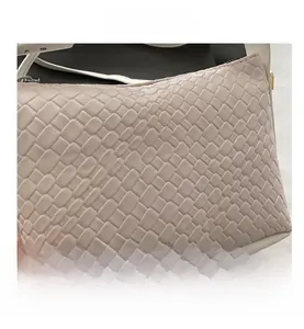 Détail macro de la texture tressée en similicuir sur le sac bandoulière beige chic