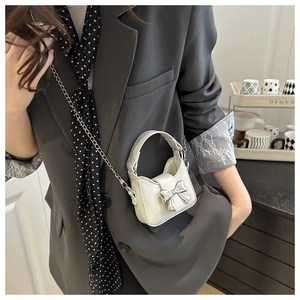 Détail du mini sac blanc avec boucle nœud argentée et bandoulière en chaîne fine