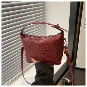 Détails de la texture tissée rouge et du fermoir argenté du sac à bandoulière carré