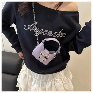 Detail of light purple mini bag with silver bow accent and metal chain strap