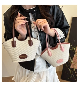 Detailaufnahme gewebter Beuteltaschen mit Griffen und rundem Fashion Markenetikett
