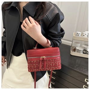 Detail of red tweed patchwork crossbody bag with gold zippers and woven texture details