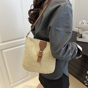 Chic woven beach crossbody bag with brown leather straps shown on a model for summer